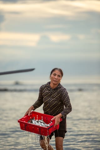 Woman carrying fishing basket seaside lifestyle.