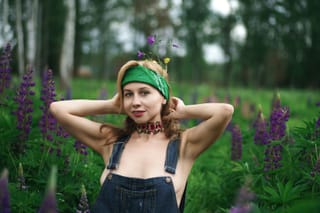 Woman green hat overalls wildflower meadow portrait.