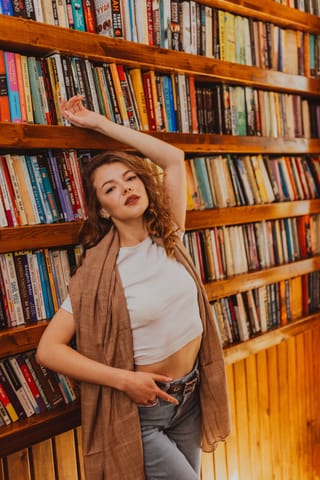 Woman posing library bookshelves casual style.