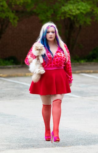 Woman red dress holding cat outdoor fashion.