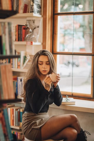 Woman sitting library window coffee tights fashion.