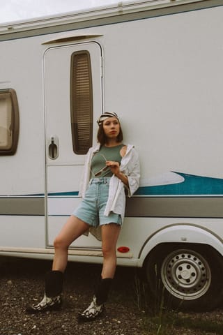 Woman standing by caravan camper travel lifestyle.