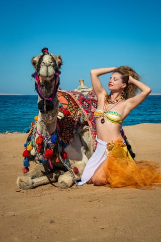 Woman with camel desert beach travel portrait.