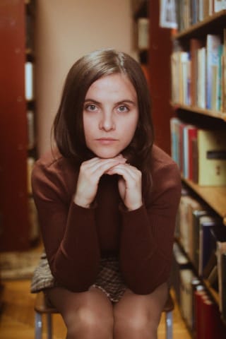 Young woman library bookshelves portrait.